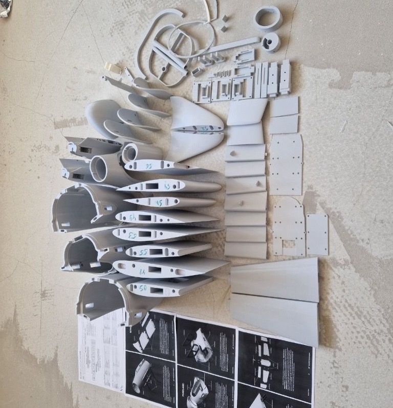 85 3D-printed BW-C45 components (79 canonical STL positions) arranged for dry-assembly staging